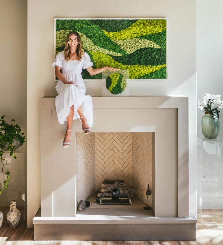Linnea Bast sits beside one of her stunning moss installations